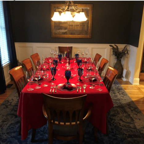 A table set with red cloth and wooden chairs.