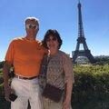 A man and woman standing in front of the eiffel tower.